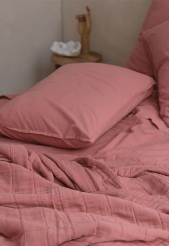 Literie rose avec oreiller et drap froissé