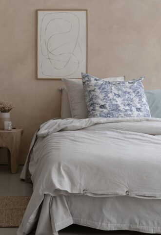 Chambre minimaliste avec lit et œuvre abstraite.