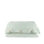 Drap housse vert pâle avec boutons visibles.