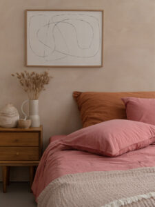 Chambre cosy avec lit rose et décor minimaliste.