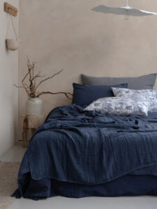 Chambre minimaliste avec lit bleu et décor naturel.