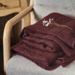 Brown blanket on chair with dried flowers