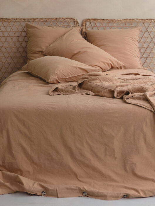 Lit avec couvre-lit beige et oreillers