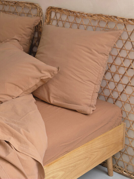 Lit beige avec tête de lit en rotin