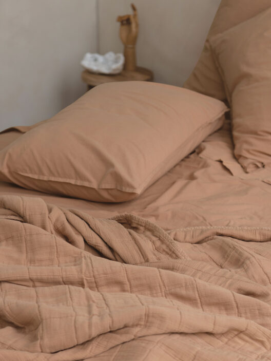 Lit avec draps beiges et décor simple
