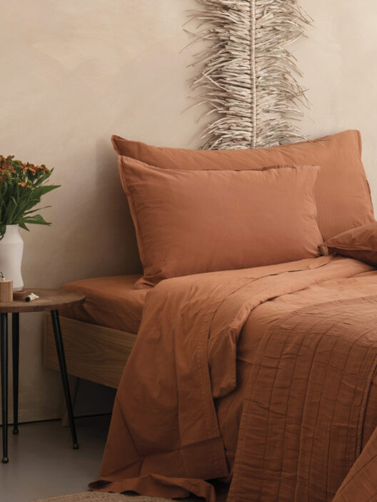 Lit avec linge de lit terracotta chaleureux