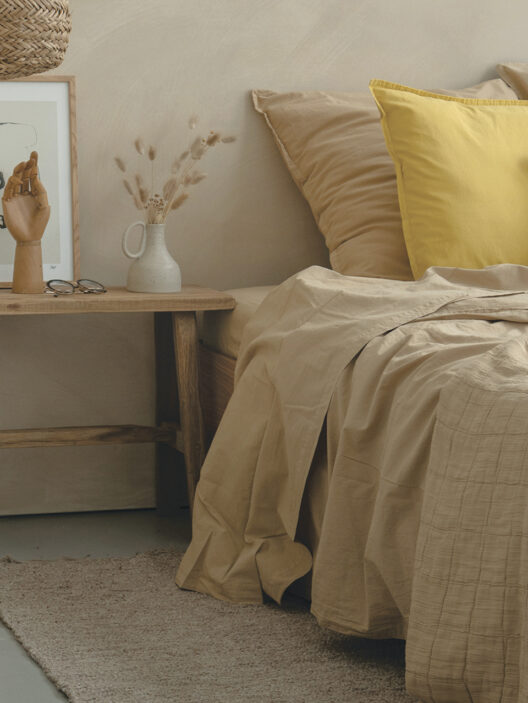 Chambre cosy avec coussins jaunes et table bois