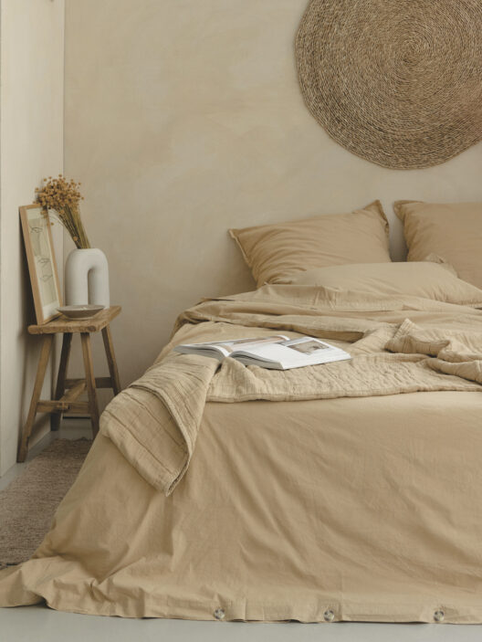 Chambre beige minimaliste avec lit et livre ouvert